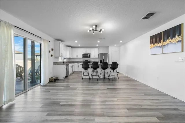 a view of kitchen with refrigerator and microwave
