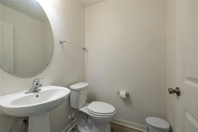 a bathroom with a sink toilet and a mirror