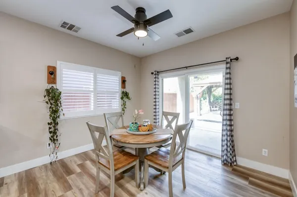 a living room with stainless steel appliances furniture a dining table and kitchen view