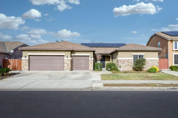 a front view of a house with a garden and pathway