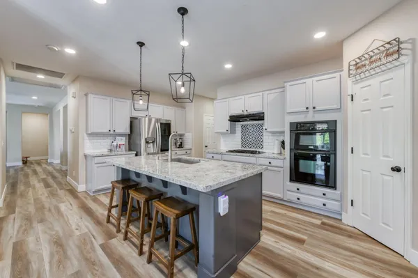 a kitchen with stainless steel appliances granite countertop a sink stove and refrigerator