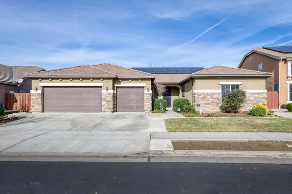 a front view of a house with a garden and garage