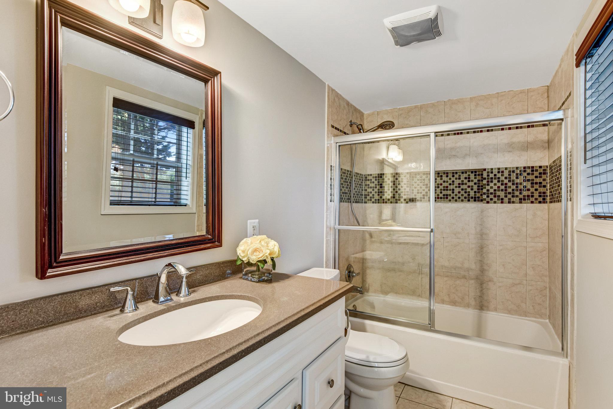 9720 Five Oaks Road Fairfax, VA 22031 - Photo 38 of 91 a bathroom with a granite countertop sink toilet a mirror and shower