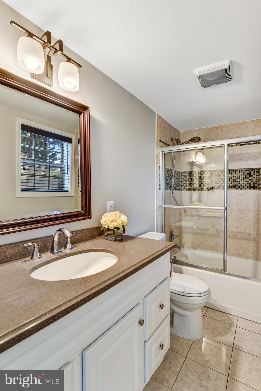 9720 Five Oaks Road Fairfax, VA 22031 - Photo 41 of 91 a bathroom with a granite countertop sink a toilet a mirror and shower