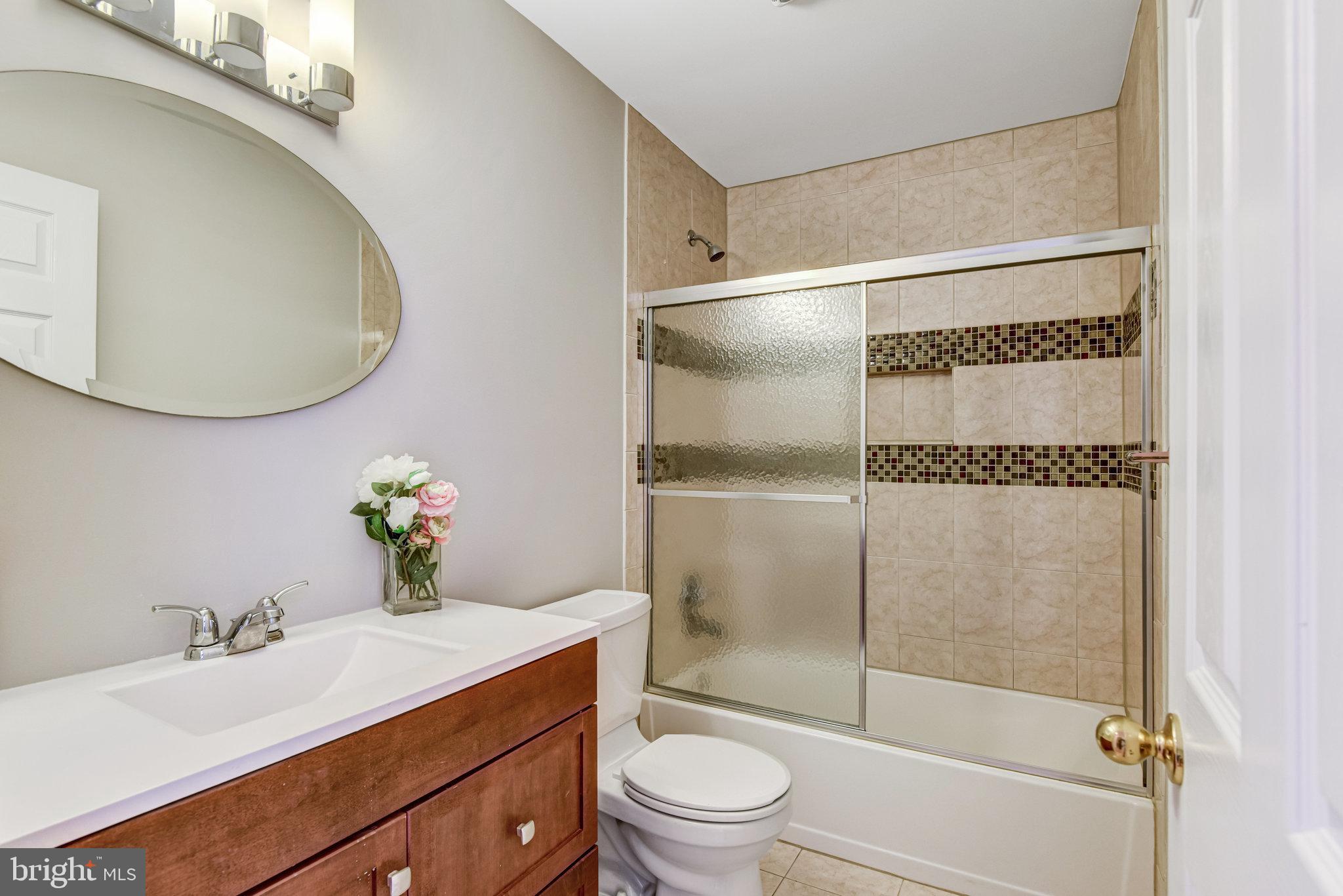 9720 Five Oaks Road Fairfax, VA 22031 - Photo 49 of 91 a bathroom with a granite countertop sink toilet a mirror and shower