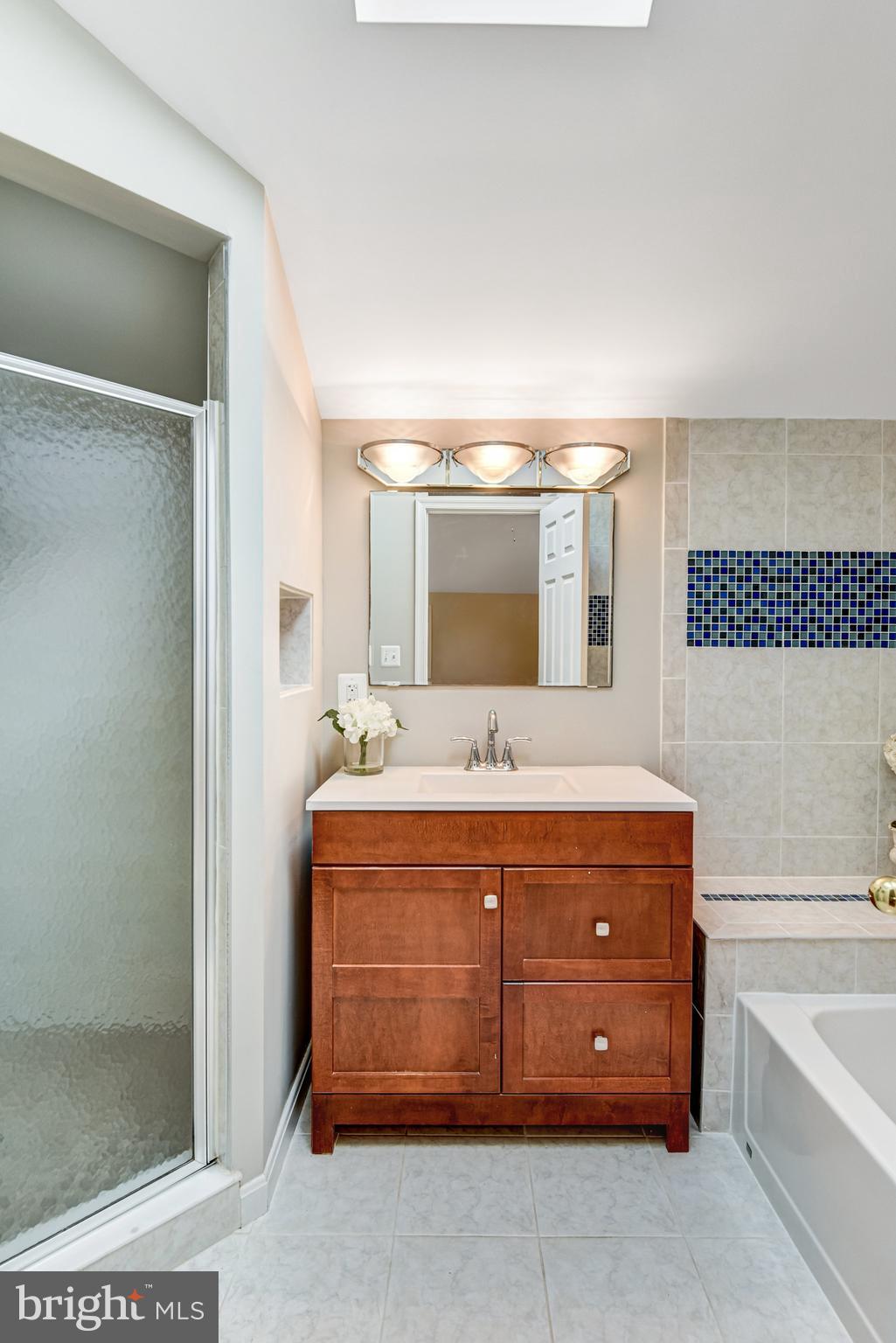 9720 Five Oaks Road Fairfax, VA 22031 - Photo 57 of 91 a bathroom with a granite countertop sink a bathtub and a mirror