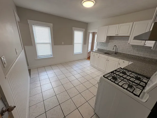 a kitchen with a sink a stove and cabinets