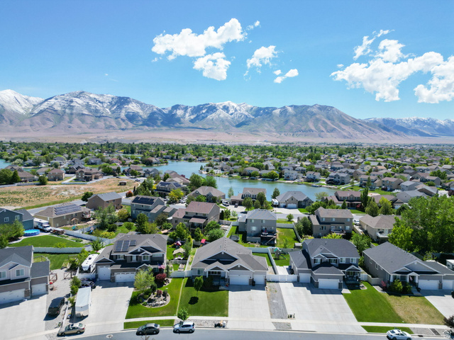 6062 Spring Street Stansbury Park, UT 84074 - Photo 34 of 36 Aerial community perspective featuring a central lake and surrounding residential properties