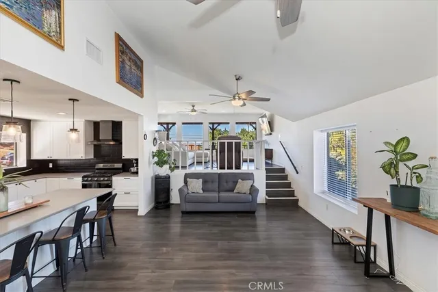 a kitchen with stainless steel appliances a refrigerator a stove a sink dishwasher a oven with white cabinets and wooden floor