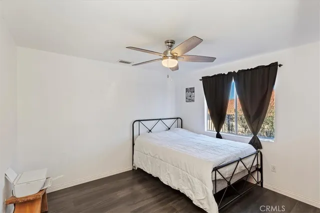 a bed room with a bed and a ceiling fan