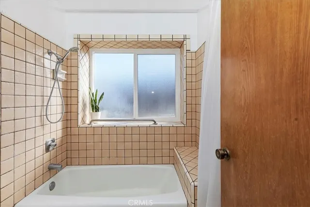 a view of a white house next to a yard with potted plants