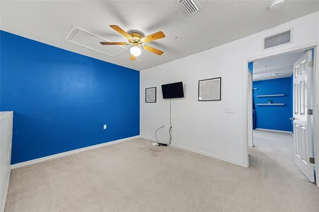 an empty room with a fireplace and large windows
