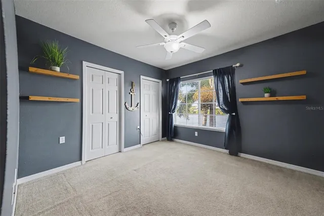 a spacious bedroom with a bed and a chandelier