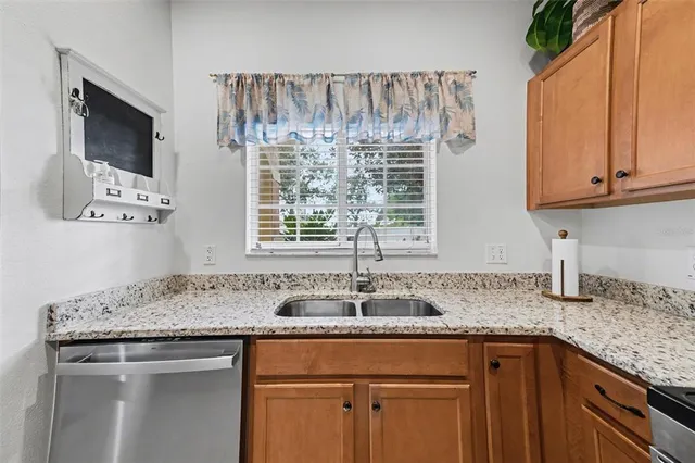 a kitchen with granite countertop a sink stainless steel appliances and cabinets