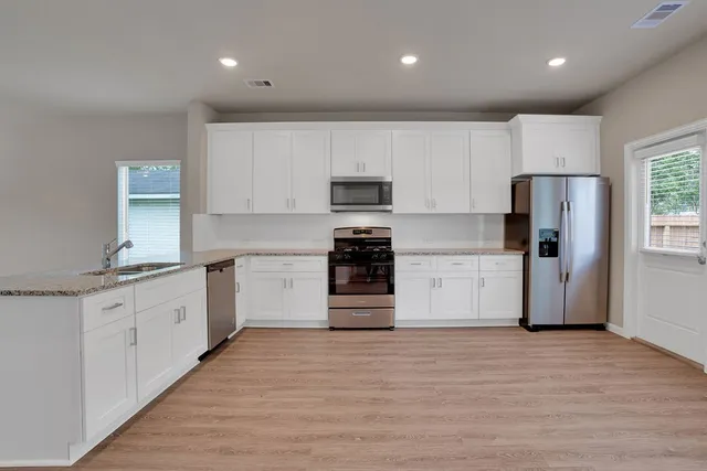 a kitchen with a refrigerator and a stove top oven