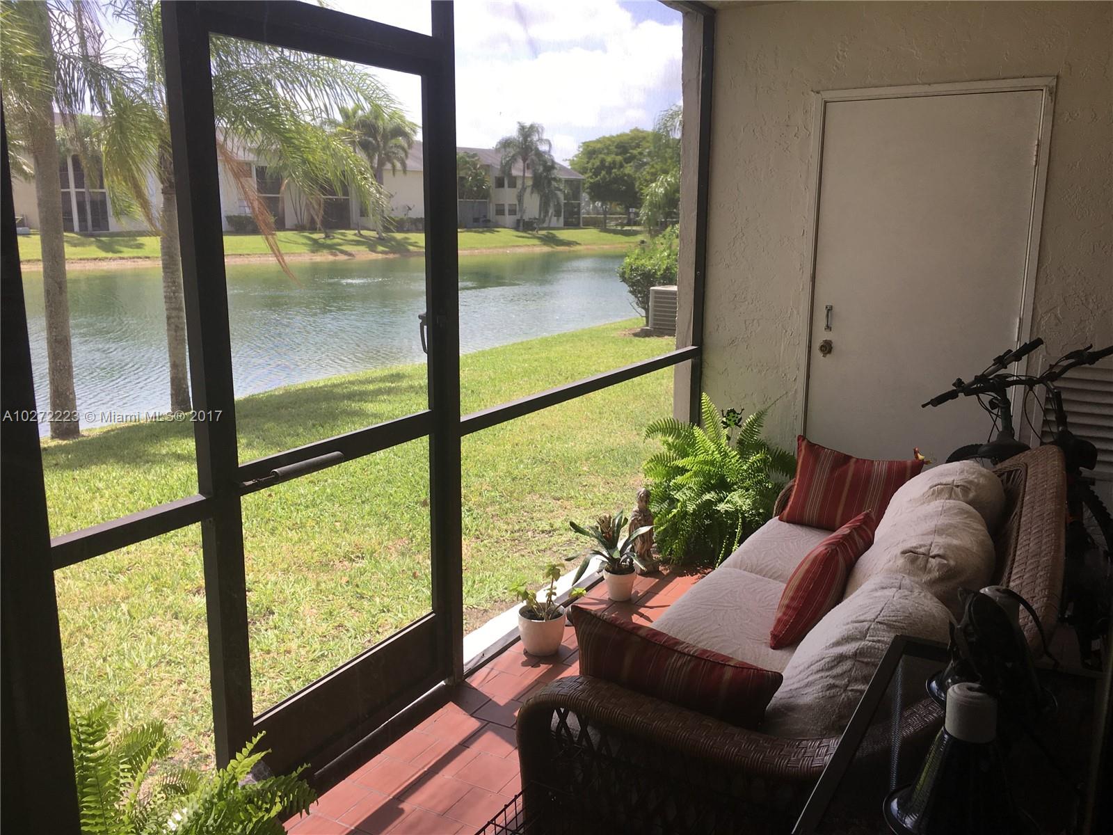 1071 Adams Avenue, Unit 1071F Homestead, FL 33034 - Photo 1 of 18 a living room with large windows and a table