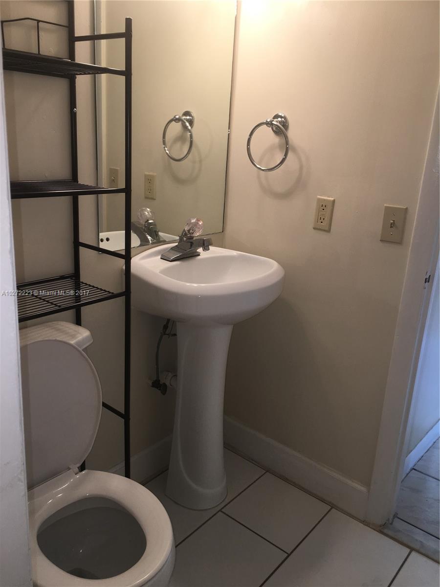 1071 Adams Avenue, Unit 1071F Homestead, FL 33034 - Photo 15 of 18 a bathroom with a toilet a sink and mirror