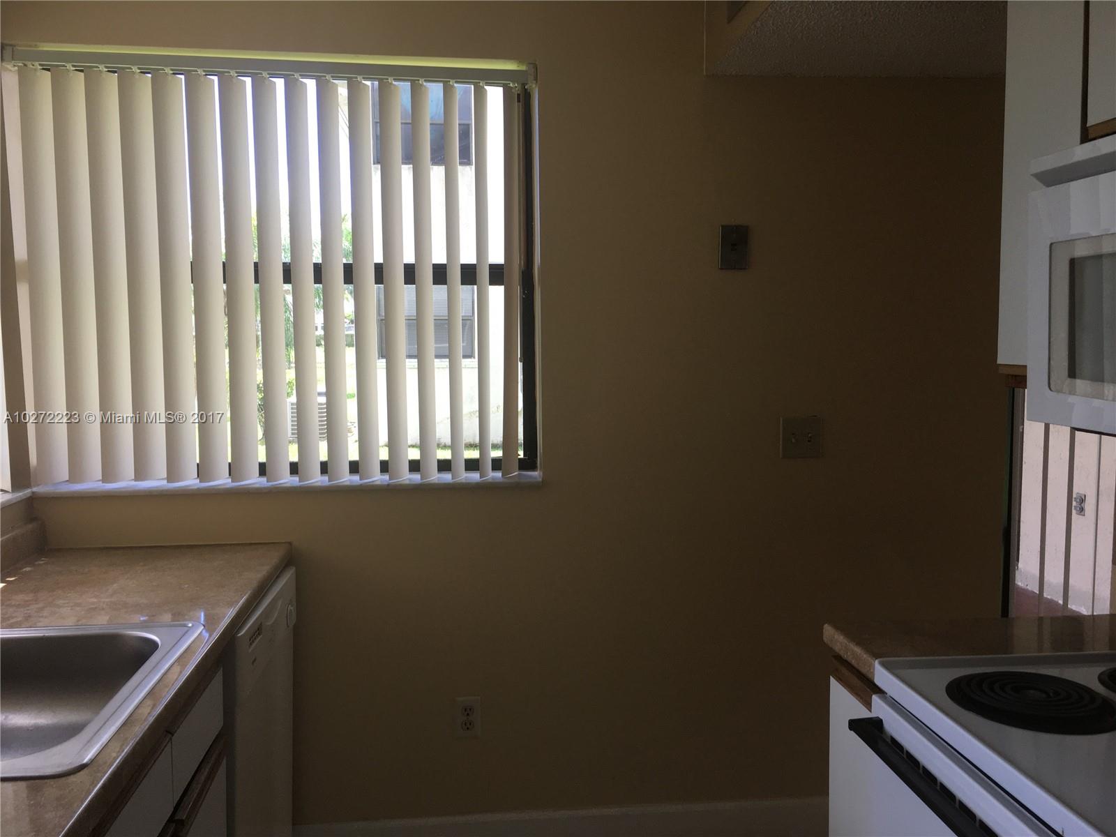 1071 Adams Avenue, Unit 1071F Homestead, FL 33034 - Photo 7 of 18 a kitchen with a sink a stove cabinets and a window