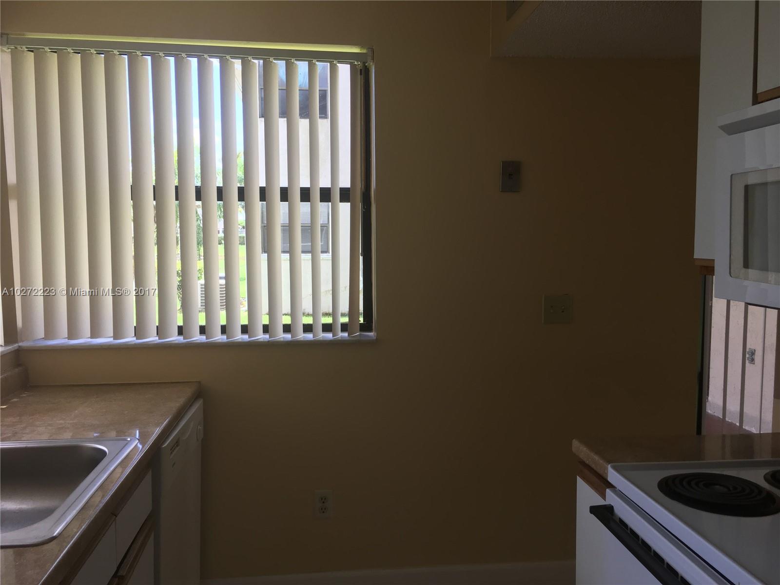1071 Adams Avenue, Unit 1071F Homestead, FL 33034 - Photo 8 of 18 a kitchen with a sink and cabinets