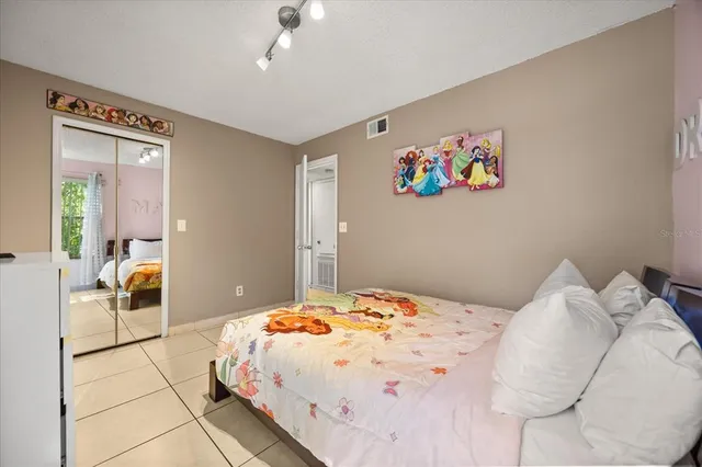 a bedroom with a bed a chandelier and dresser