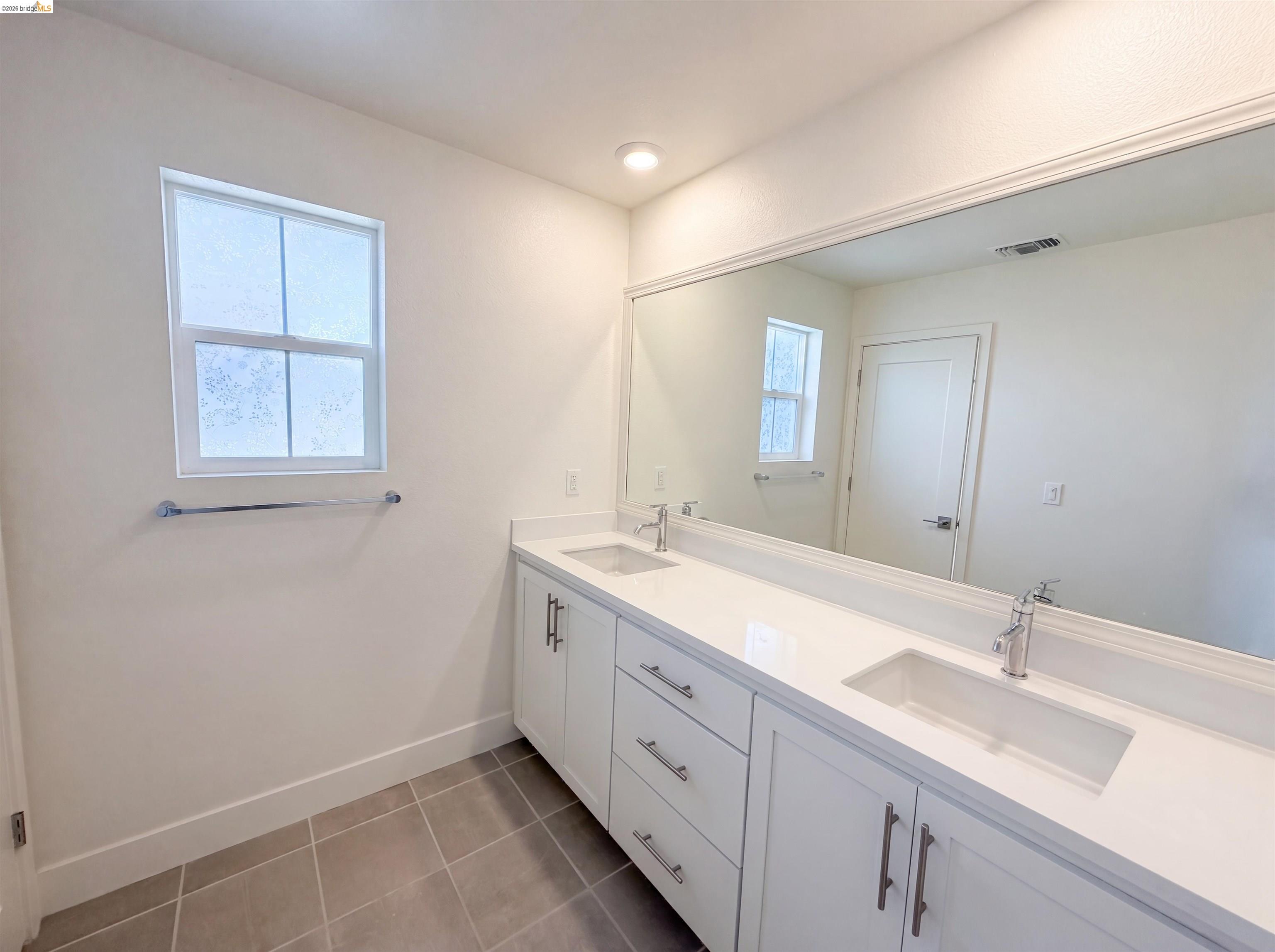 9034 Rudder Way Newark, CA 94560 - Photo 17 of 38 Double vanity with white cabinetry, integrated sinks, chrome fixtures, and a large wall-mounted mirror