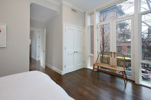 a bedroom with wooden floor and a window