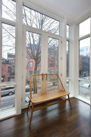 a view of an empty room with wooden floor and windows