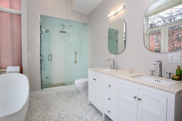 a spacious bathroom with a double vanity sink mirror and bathtub