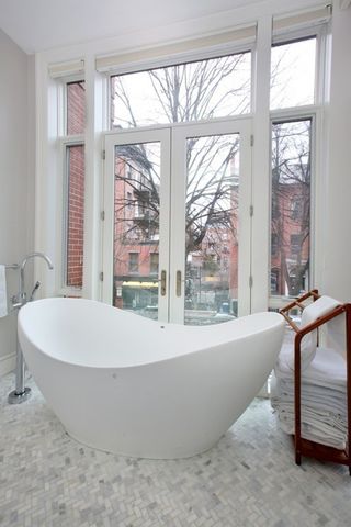 a white bath tub sitting in front of a window