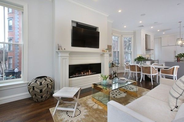 a living room with furniture a flat screen tv and a fireplace