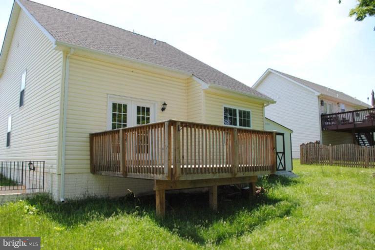 440 Ford Circle Inwood, WV 25428 - Photo 8 of 8 a backyard of a house with a garden and deck