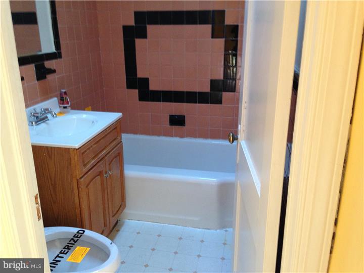 6316 Jackson Street Philadelphia, PA 19135 - Photo 7 of 14 a bathroom with a tub sink and mirror