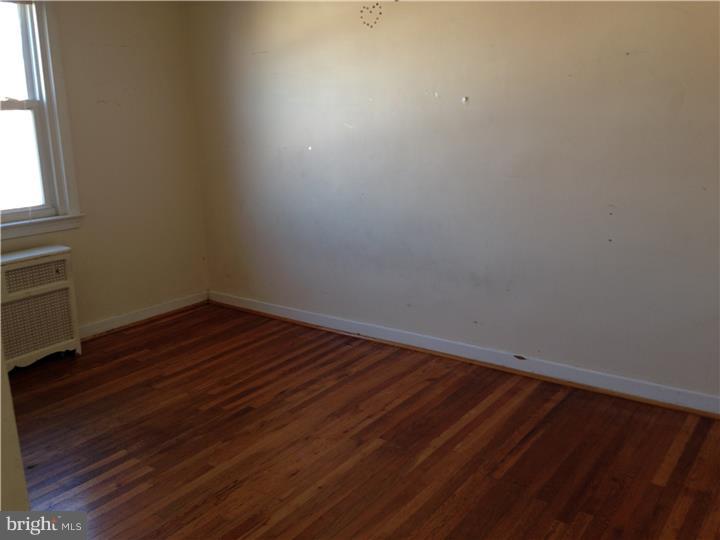 6316 Jackson Street Philadelphia, PA 19135 - Photo 8 of 14 a view of an empty room with wooden floor and a window