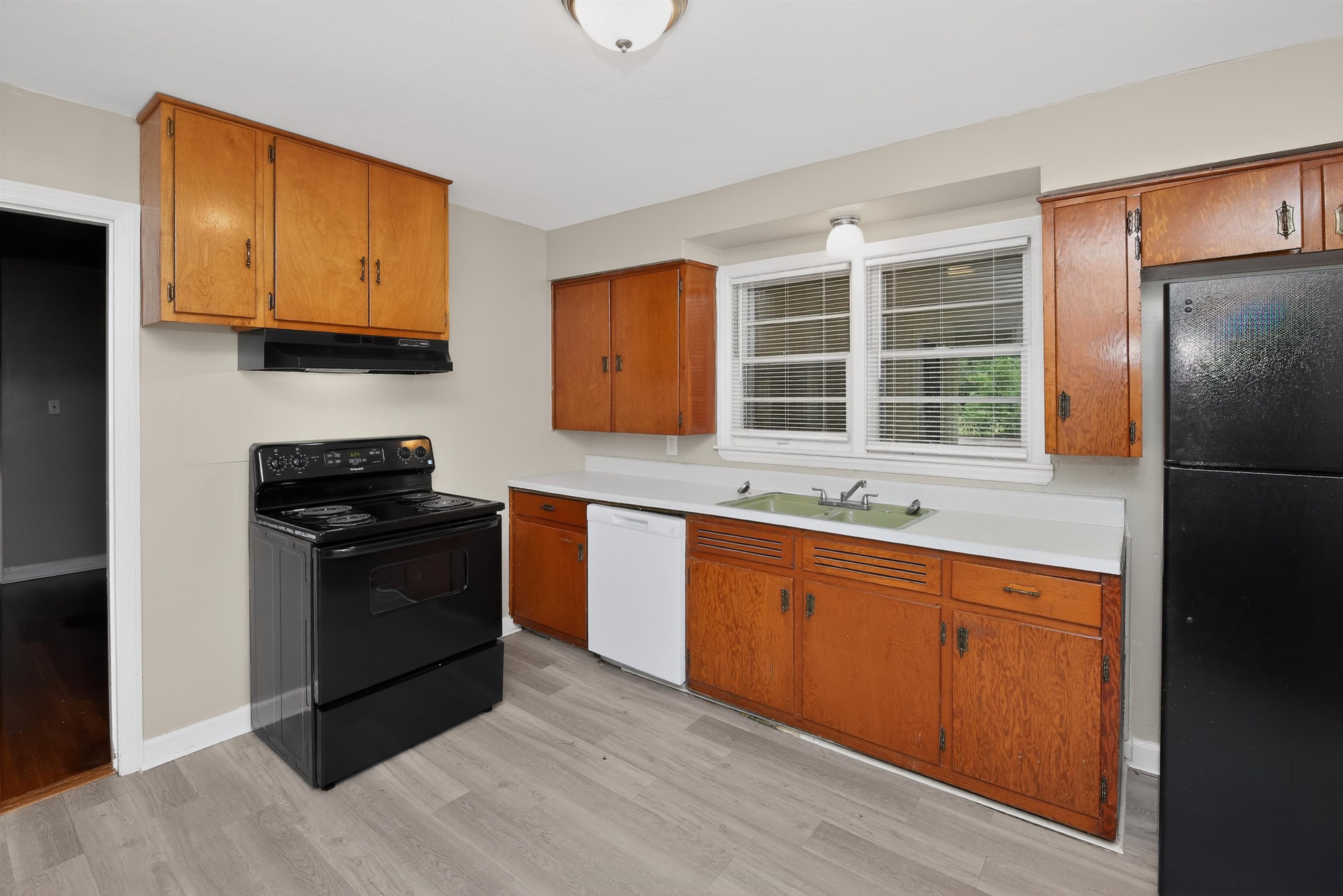 2840 Allen Road Memphis, TN 38128 - Photo 22 of 31 Kitchen featuring light wood-finish cabinetry, a black electric range, a black refrigerator, a white dishwasher, and light-tone flooring
