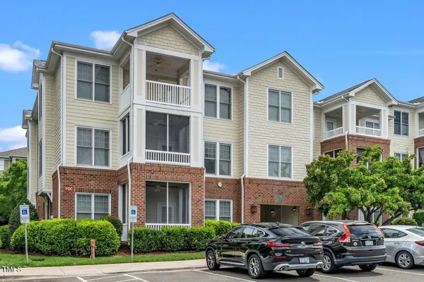 a front view of a residential apartment building with a yard