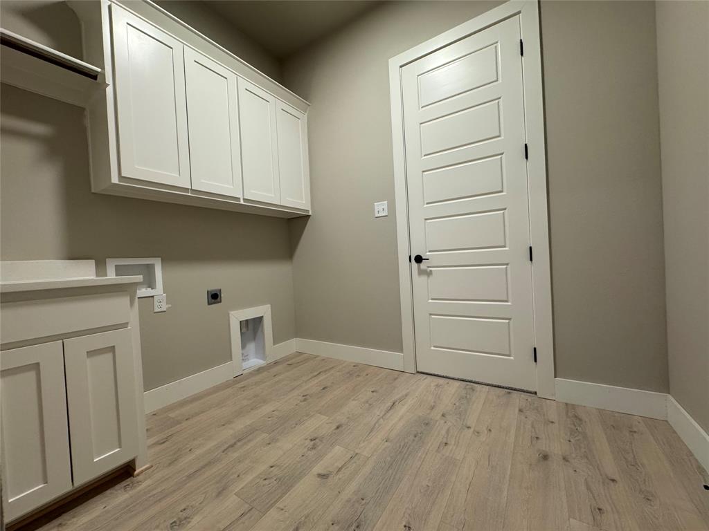 129 Mikasi Street Godley, TX 76044 - Photo 15 of 21 a view of a kitchen with white cabinets and wooden floor