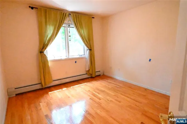 a view of a room with wooden floor and white walls