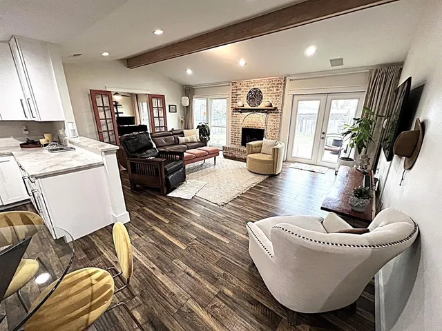 a living room with furniture kitchen view and a large window