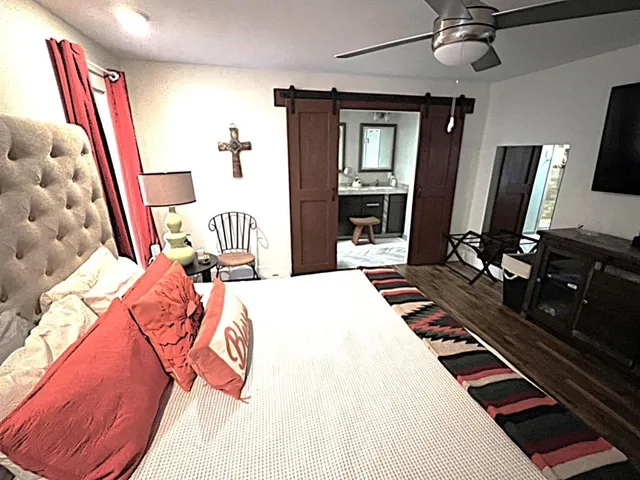 a bedroom with a bed flat screen tv and a window