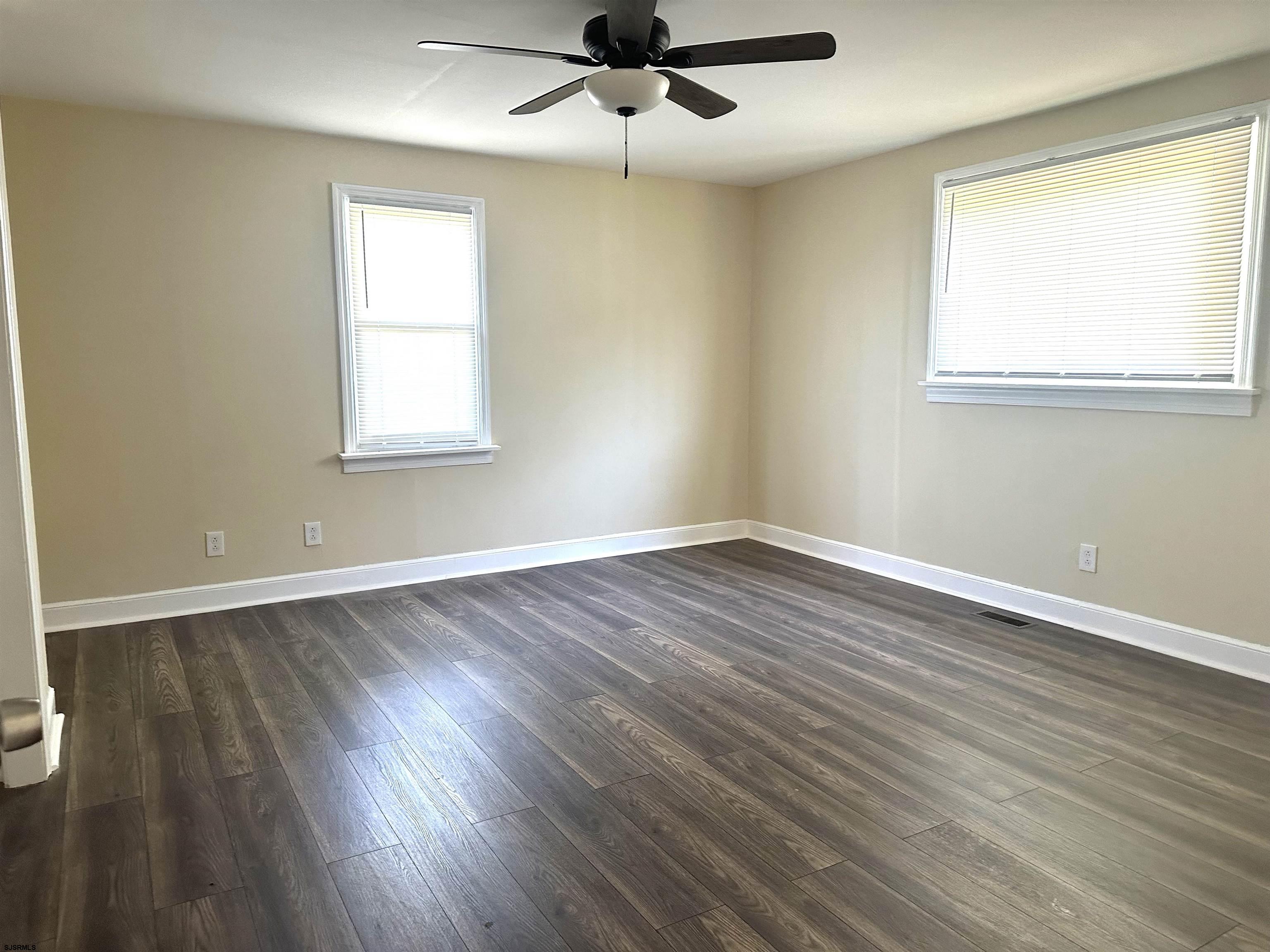 2 Creek Road Absecon, NJ 08201 - Photo 14 of 24 an empty room with wooden floor a ceiling fan and windows