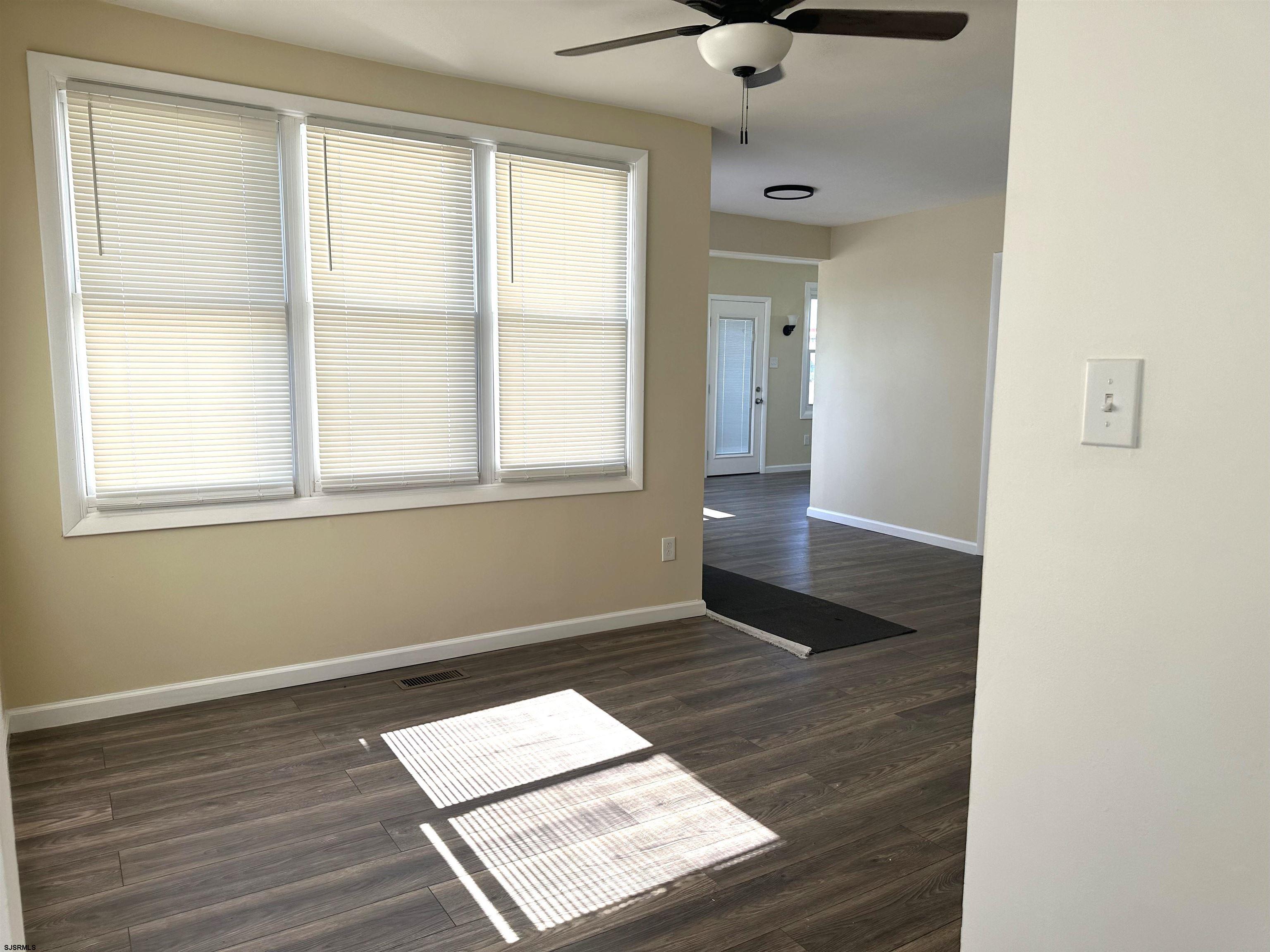 2 Creek Road Absecon, NJ 08201 - Photo 9 of 24 an empty room with wooden floor cabinet and windows
