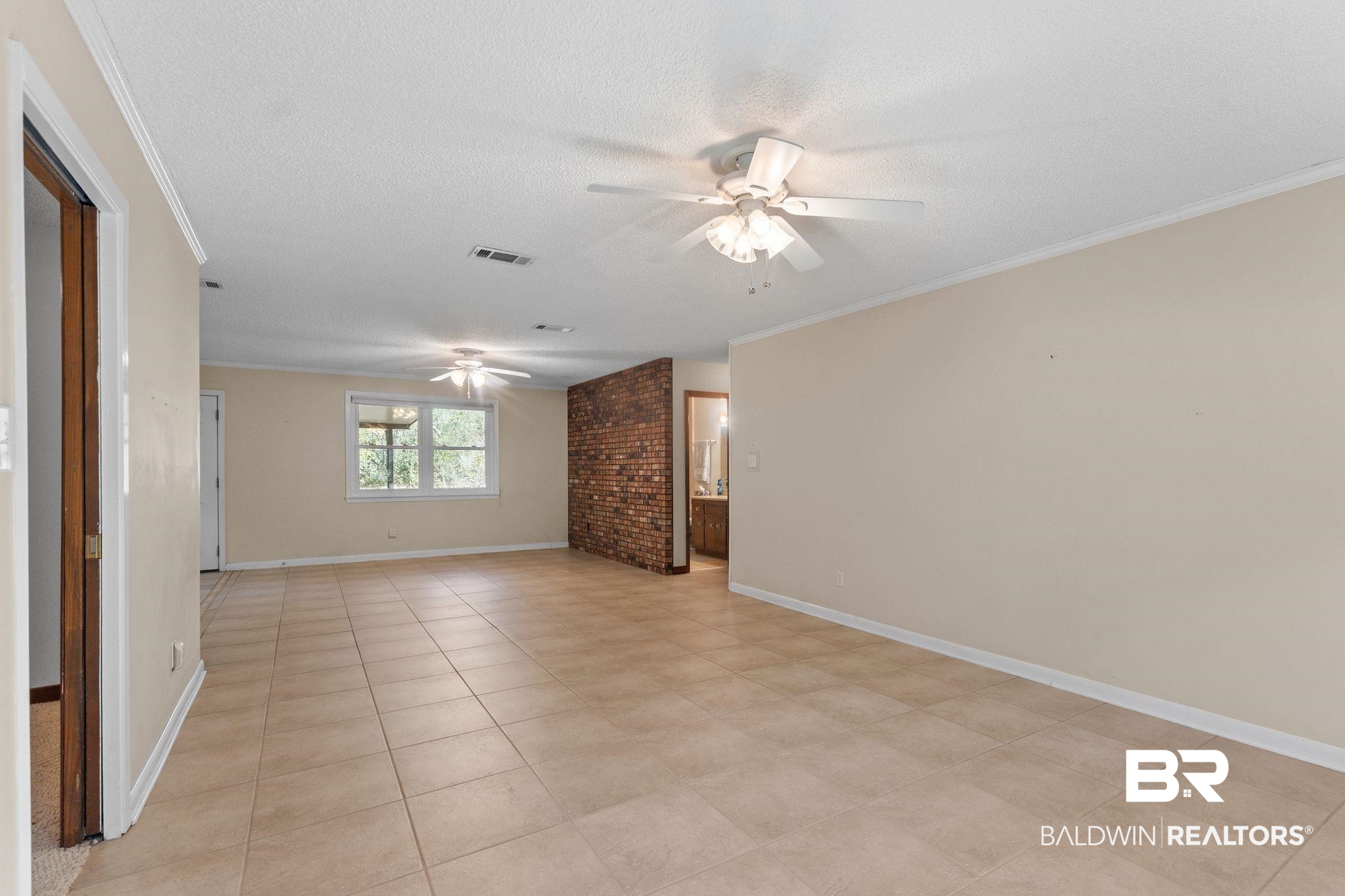 32989 Antietam Road Lillian, AL 36549 - Photo 8 of 56 Empty room featuring ornamental molding, a textured ceiling, ceiling fan, and light tile patterned flooring