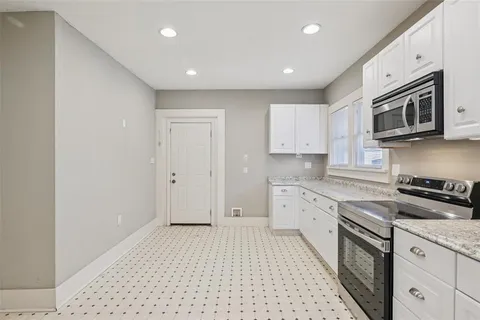 a large kitchen with stainless steel appliances granite countertop a stove a sink and a microwave