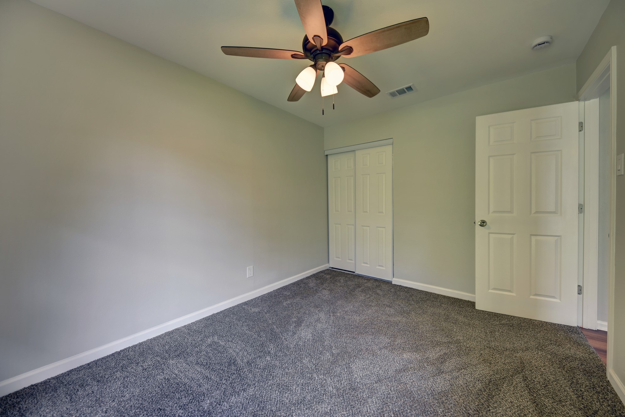 806 West Jefferson Street Brenham, TX 77833 - Photo 13 of 20 an empty room with a chandelier fan and windows