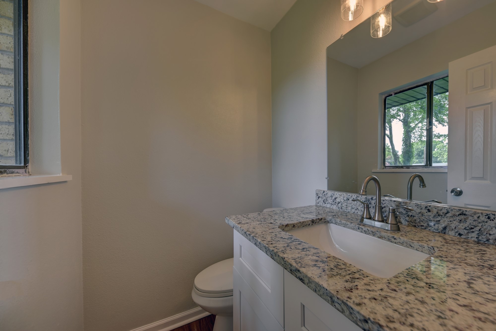 806 West Jefferson Street Brenham, TX 77833 - Photo 15 of 20 a bathroom with a granite countertop sink and a toilet