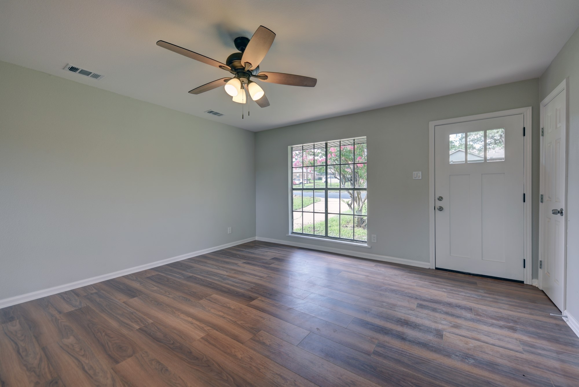 806 West Jefferson Street Brenham, TX 77833 - Photo 4 of 20 an empty room with wooden floor fan and windows