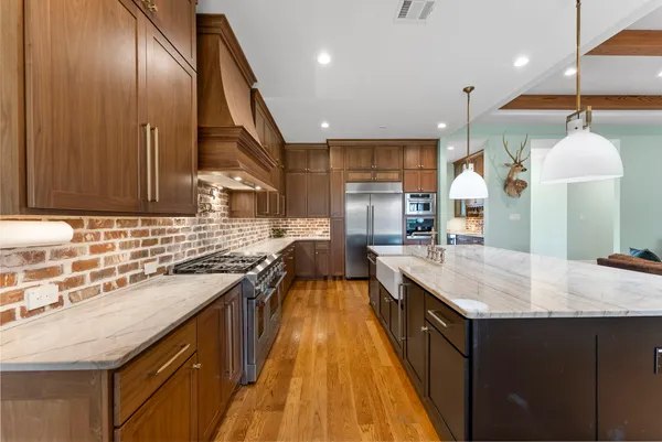 a kitchen with stainless steel appliances granite countertop sink stove and wooden cabinets