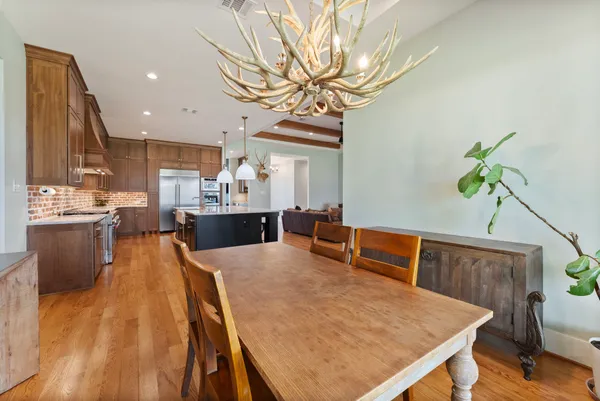 a living room with stainless steel appliances furniture a rug and a kitchen view