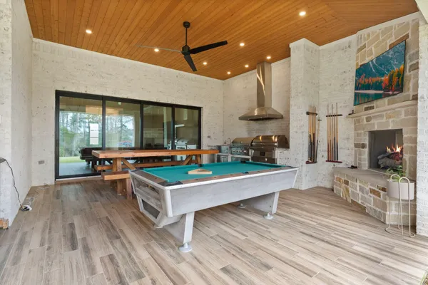 a room with stainless steel appliances a table chairs and a kitchen view