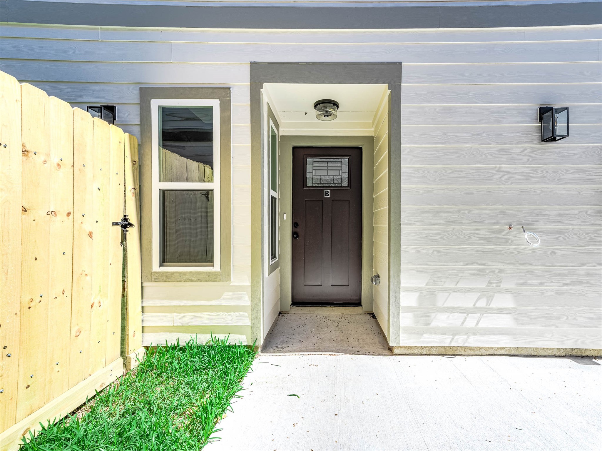 2018 Hampton Street, Unit B Houston, TX 77088 - Photo 28 of 30 This photo features a modern front door with a sleek design, incorporating a glass panel. It's set within a clean, neutral-toned entryway that highlights the contemporary style for the home.